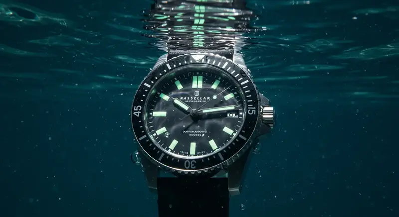 Reloj de buceo profesional sumergido en el agua, mostrando el bisel unidireccional utilizado para medir el tiempo de inmersión.