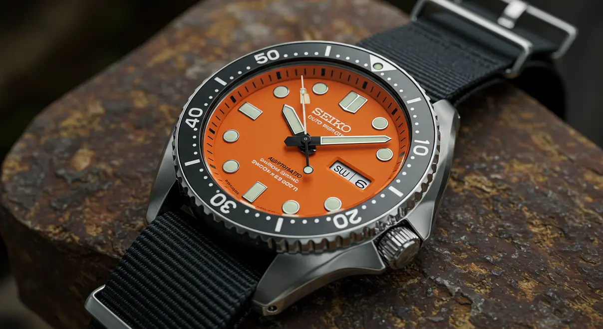 Reloj Seiko personalizado con esfera naranja y detalles en negro, mostrando un cristal de zafiro.