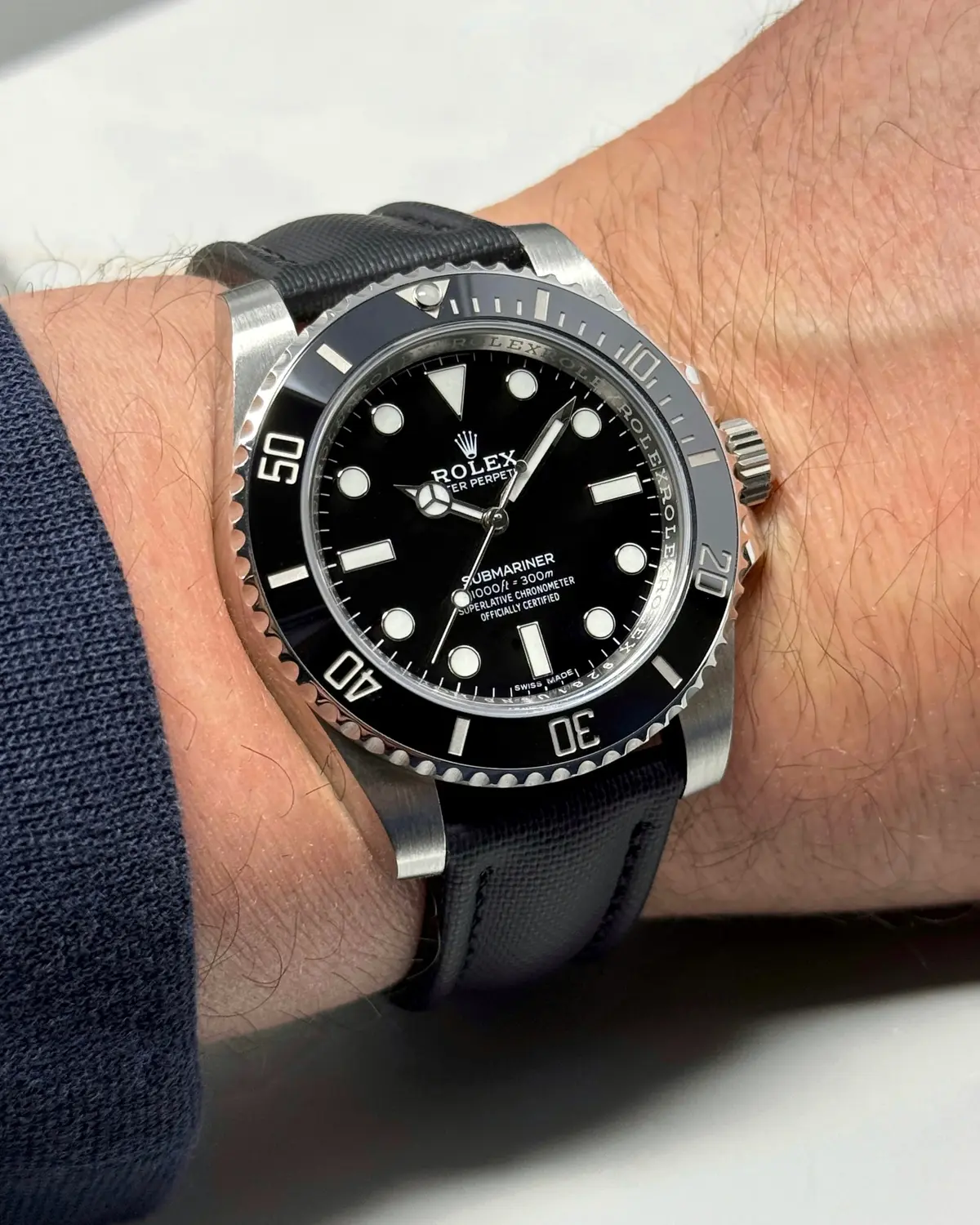 Correas de Reloj: La Arquitectura del Tacto 6 Correa Sailcloth negra elegante en muñeca con reloj clásico, combinación perfecta de textura técnica y estética formal premium