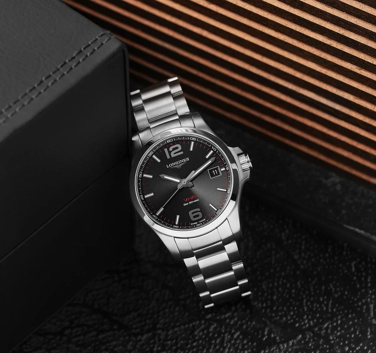 Reloj Longines Conquest V.H.P. 41mm esfera negra brazalete acero sobre madera